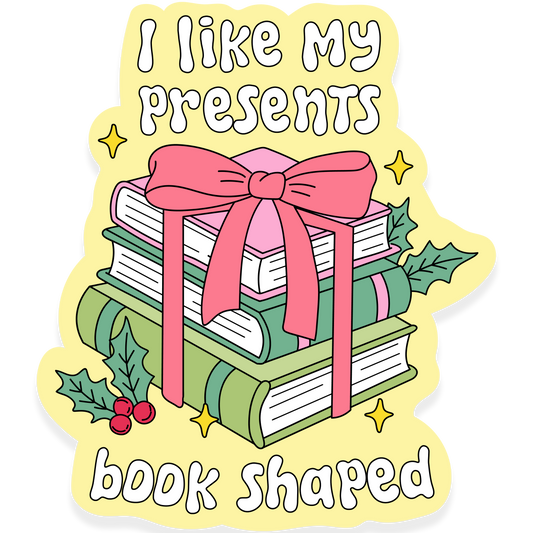 Stack of books wrapped with a pink bow and holly leaves with the phrase 'I like my presents book shaped.'